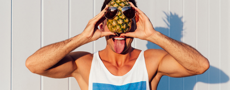 man smiling tongue out with pineapple