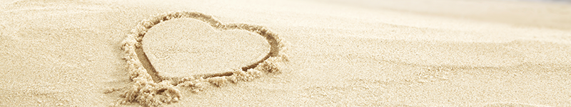 heart drawn into sand on beach