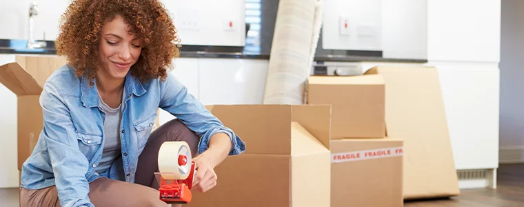 Woman Sealing Boxes Ready For House Move