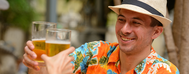 man in aloha shirt drinking beer